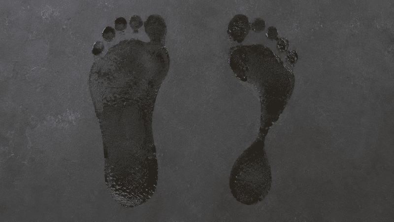 Side by side comparison of a flat foot imprint and a high arch foot imprint on a surface, showing the difference in arch height between the two foot types
